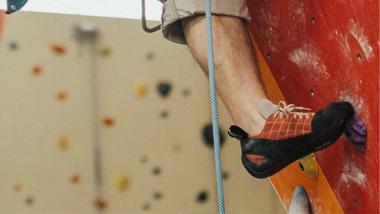 Close-up of an indoor climber's shoe on a hold