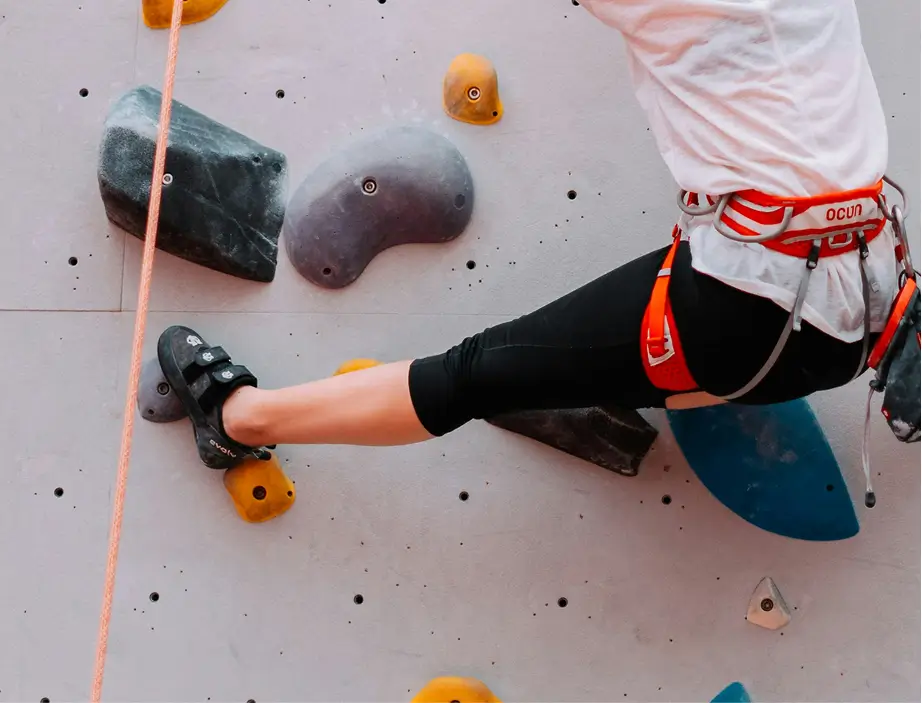 Indoor rock climber wearing rental climbing shoes